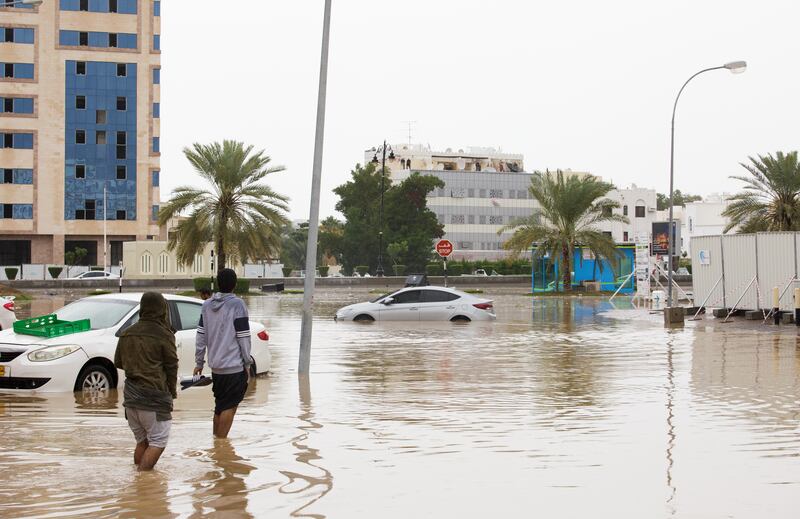 People wade through floodwaters in the capital.