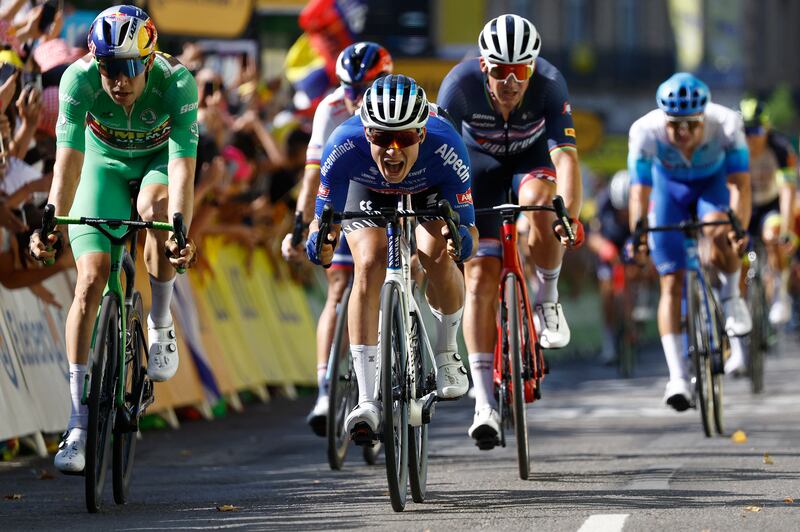 Jasper Philipsen celebrates as he crosses the finish line to win Stage 15. Reuters