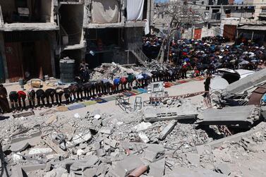 Palestinians pray in front of the ruins of Al Farouq mosque in Rafah, southern Gaza. AFP