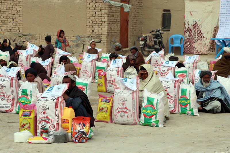 People receive food rations distributed by the Afghan Charity Foundation in Kandahar. EPA