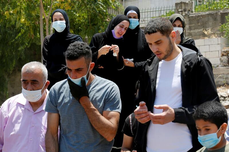 Mourners attend the burial of a Palestinian man who died after contracting Covid-19, in a cemetery in Hebron in the Israeli-occupied West Bank. Reuters