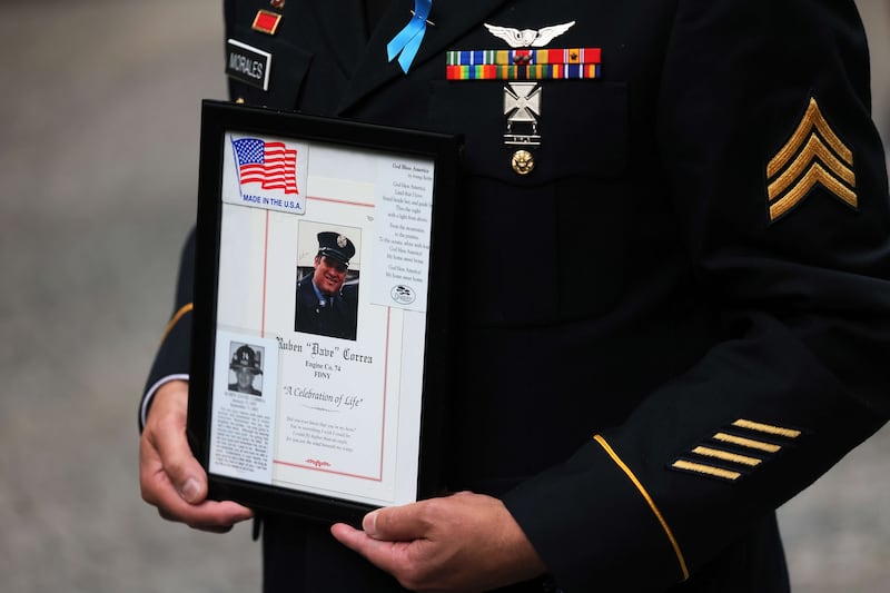 Sergeant Edwin Morales holds a photo of his cousin Ruben 'Dave' Correa during the annual 9/11 Commemoration Ceremony at the National 9/11 Memorial and Museum. AFP