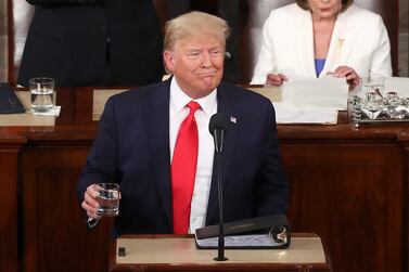 President Donald Trump holds a glass of water during the State of the Union address. Getty Images / AFP