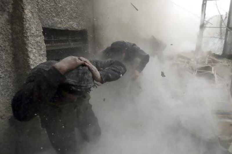 Free Syrian Army fighters run for cover as a tank shell explodes on a wall during heavy fighting in Damascus. Israel’s attack on a Syrian weapons haul has prompted fears Syria’s war will escalate past the existing boundaries.