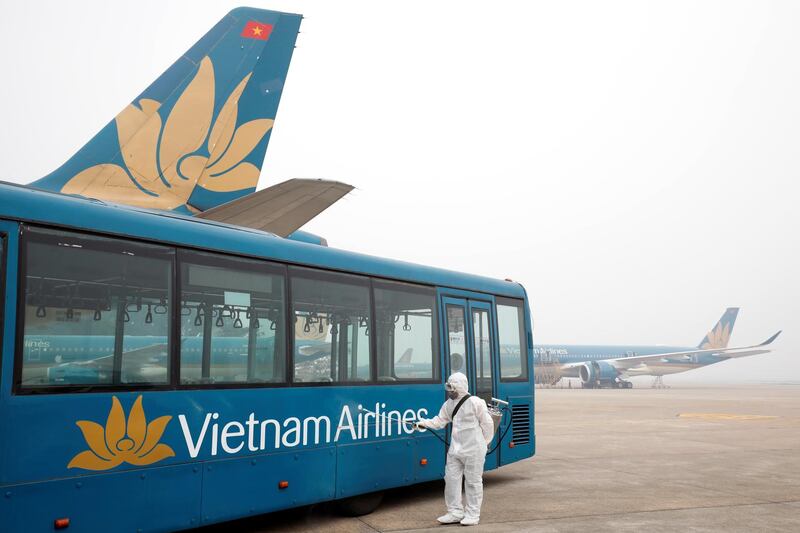 A health worker sprays disinfectant outside a bus to protect from the recent coronavirus outbreak, at Noi Bai airport in Hanoi, Vietnam. Reuters