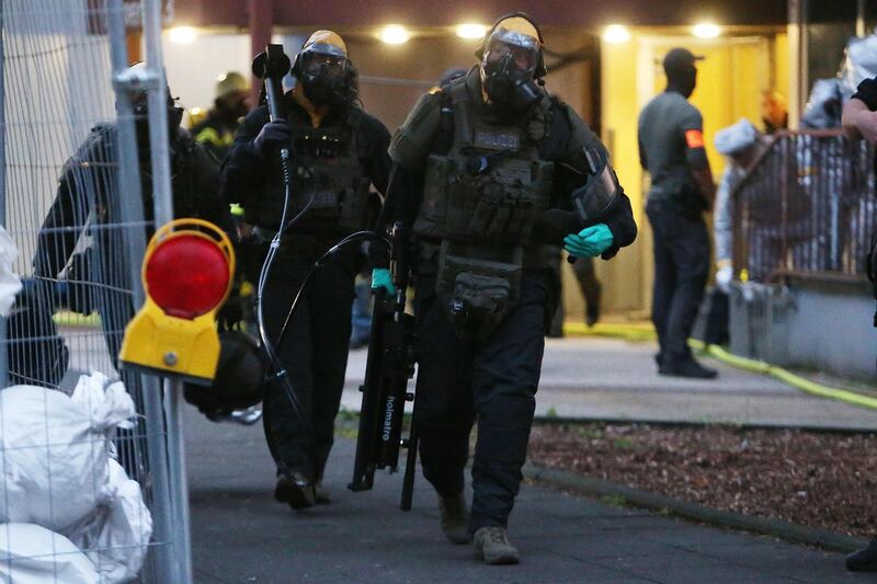 Police officers, including special forces wearing protective suits walk out of a building on late June 12, 2018 in Cologne, where German police have arrested a Tunisian man after discovering "toxic substances" at his flat.   The man and his wife, whose nationality was not released, were detained late June 12, 2018 after officers raided their flat and came across "unknown substances" that are now being analysed by specialists, Cologne police said in a statement. - Germany OUT
 / AFP / dpa / David Young

