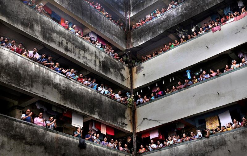 People clap from balconies in a show of appreciation for health care workers in Mumbai, India, on March 22, 2020. AP Photo