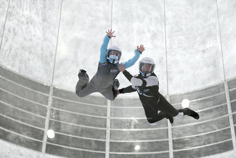 Abu Dhabi, United Arab Emirates - Samih, 9, takes flight with the help of the instructor during the indoor skydiving adventure at CLYMB, Yas Island. Khushnum Bhandari for The National