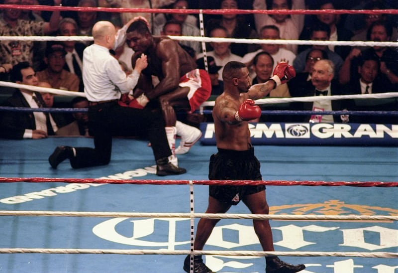 16 Mar 1996: Mike Tyson celebrates his win while Frank Bruno of Great Britain is attended by referee Mills Lane in the third round during the WBC Heavyweight Championship bout at the MGM Grand Garden in Las Vegas, Nevada. Tyson won the title with a technical knockout in the third round. Mandatory Credit: John Gichigi  /Allsport / Getty Images