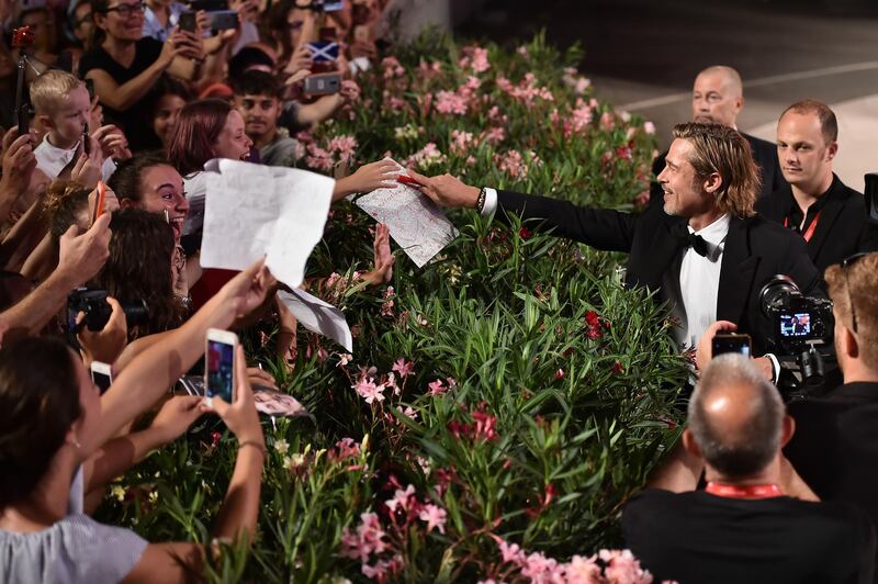 Pitt signs autographs on the red carpet. Getty Images