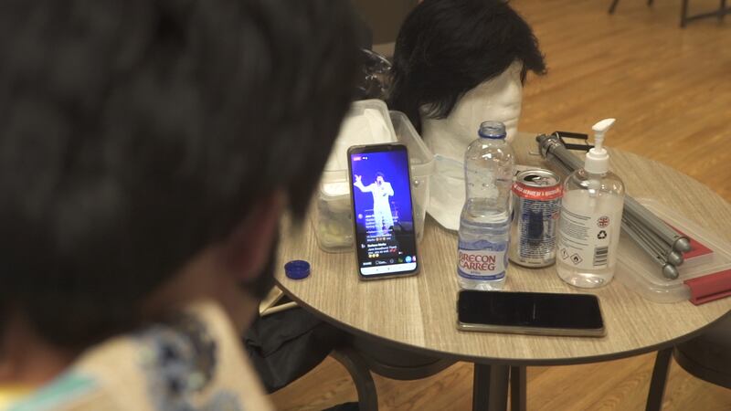 An Elvis tribute act watches a livestream of  fellow competitors at Porthcawl's Grand Pavilion.