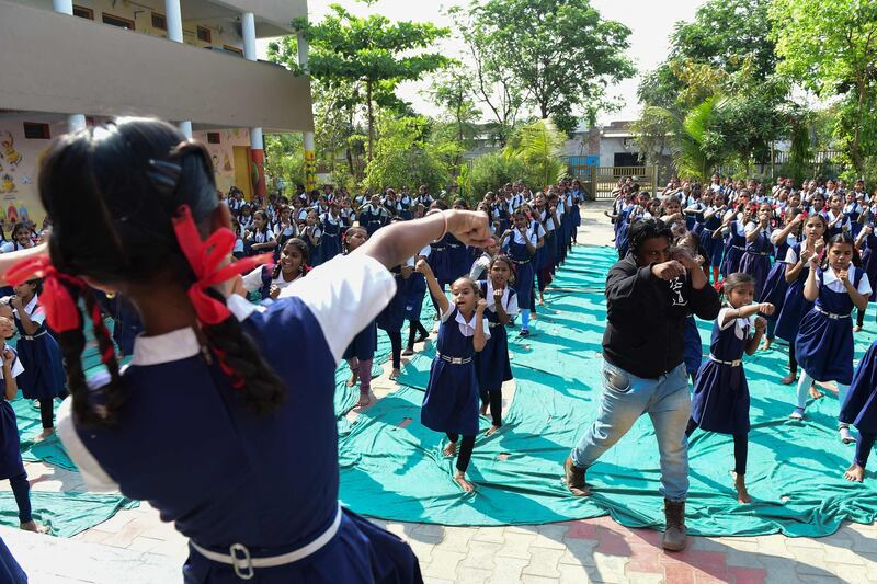 An instructor leads schoolgirls at a martial arts class for self-defence at a school in Ahmedabad, India. AFP