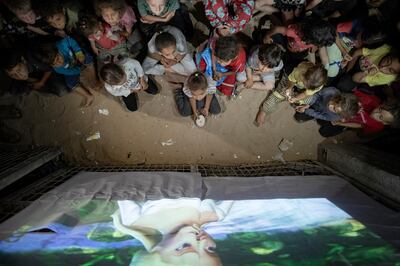 Children gather at a makeshift cinema set up among the tents of the Rafah refugee camp. EPA 