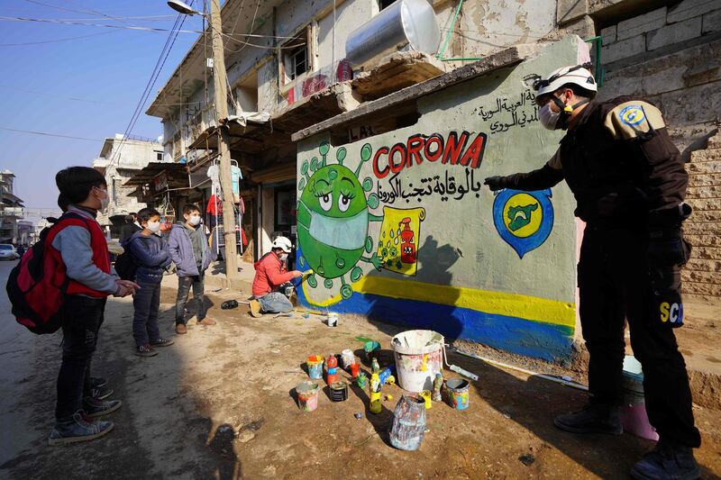 A member of the Syrian Civil Defence group known as the White Helmets instructs school children about the coronavirus during an awareness campaign organised in the town of Binnish in Syria's northwestern Idlib province.  AFP