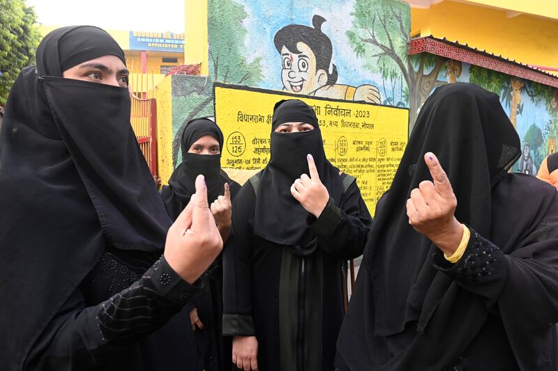 Women display indelible ink marks after casting their votes for state elections in Bhopal, Madhya Pradesh, on Friday. AP
