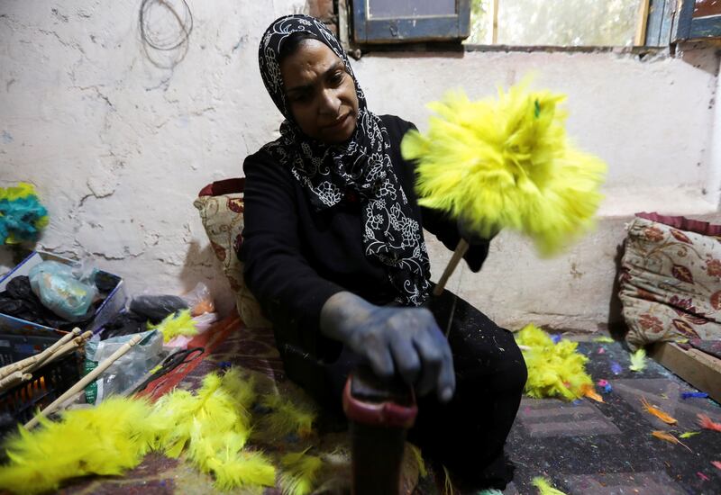 Doaa Muhammad, 44, prepares her feather dusters and other products for sale in Cairo.
