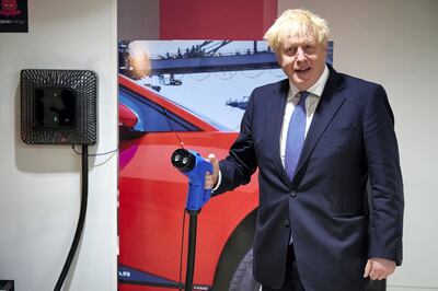 LONDON, ENGLAND - OCTOBER 05: Prime Minister Boris Johnson holds an electric vehicle charging cable as he visits the headquarters of Octopus Energy on October 05, 2020 in London, England. The prime minister and Chancellor of Exchequer Rishi Sunak visited the British "tech unicorn" - a startup company valued at more than USD$1 billion - to promote the company's plan to create 1,000 new technology jobs across sites in London, Brighton, Warwick and Leicester, and a new tech hub in Manchester. (Photo by Leon Neal - WPA Pool /Getty Images)
