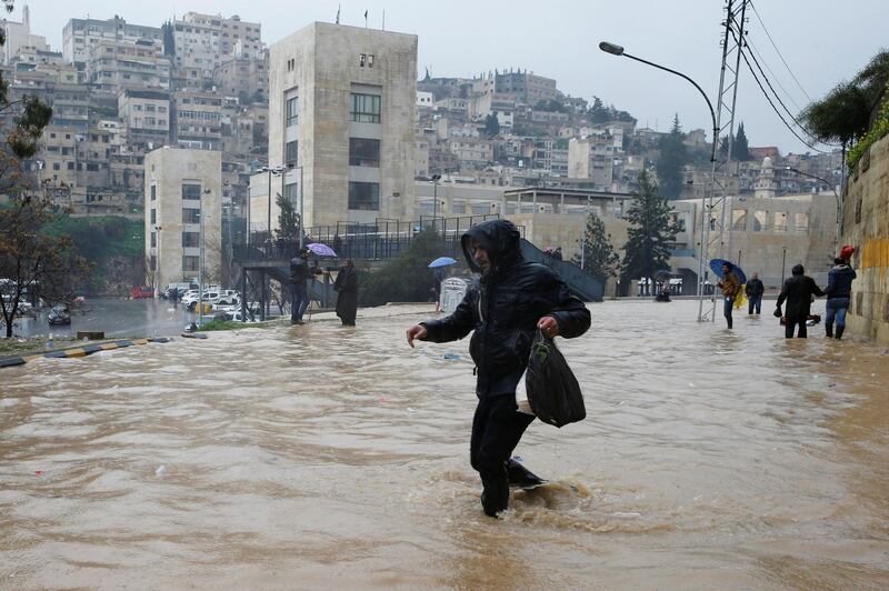 A man crosses a flooded street during heavy rains in Amman. Reuters