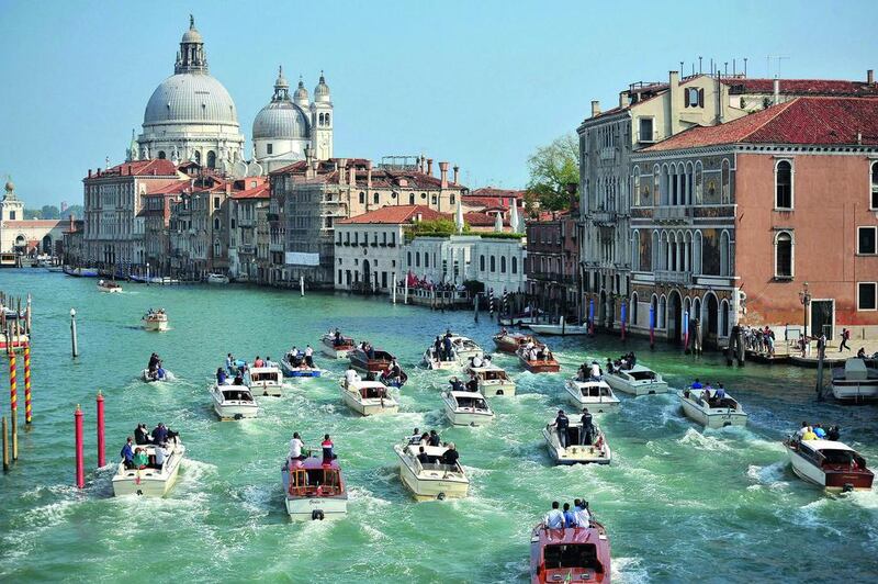 The boat carrying the newly-weds George Clooney and Amal Alamuddin, surrounded by media and security boats as they cruise the Grand Canal after leaving the Aman luxury hotel in Venice, last month. Luigi Costantini / AP Photo