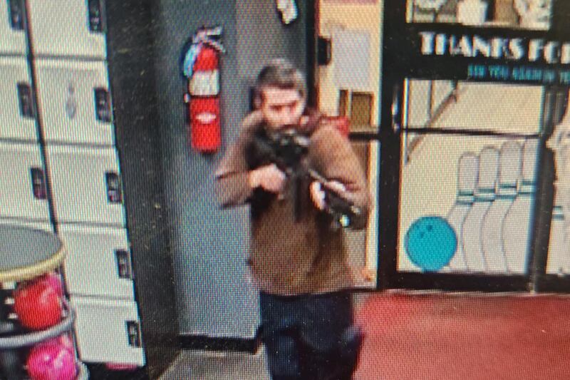 A picture of the suspect pointing what appears to be a semi-automatic rifle. AFP