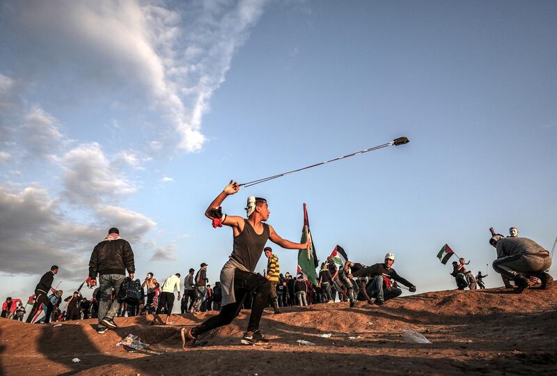 epa07243808 A Palestinian protester throw stones by his slingshot at Israeli troops during the clahses after Friday protests near the border between Israel and Gaza Strip in the east Gaza Strip, 21 December 2018. Sixsteen year old boy Mohammed Jahjouh was allegedly shot dead and more the 60 others wounded during the clashes near the border eastern Gaza Strip. Protesters call for the right of Palestinian refugees across the Middle East to return to homes they fled in the war surrounding the 1948 creation of Israel.  EPA/MOHAMMED SABER