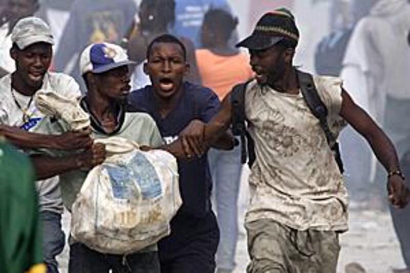 Looters fight for a bag of materials in the Haitian capital Port-au-Prince on Saturday.