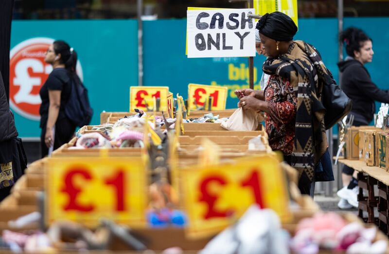 A customer browses items on a market stall selling hair accessories in Barking, UK, as data shows inflation fell slightly in August. Bloomberg