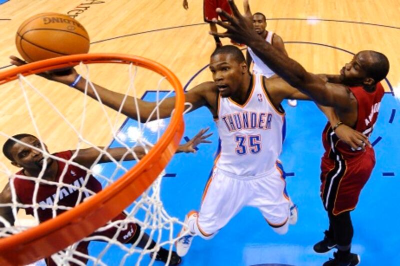 epa03159352 Oklahoma City Thunder player Kevin Durant (L) goes to the basket against the Miami Heat in the half of the game at the Chesapeake Energy Arena in Oklahoma City, Oklahoma, USA, 25 March 2012.  EPA/LARRY W. SMITH CORBIS OUT *** Local Caption ***  03159352.jpg