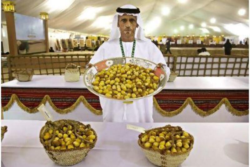 Mohammad Saeed, one of the judges, holds a platter of Khalas dates before they are assessed at the first Ajman-Liwa date festival. Jeff Topping / The National