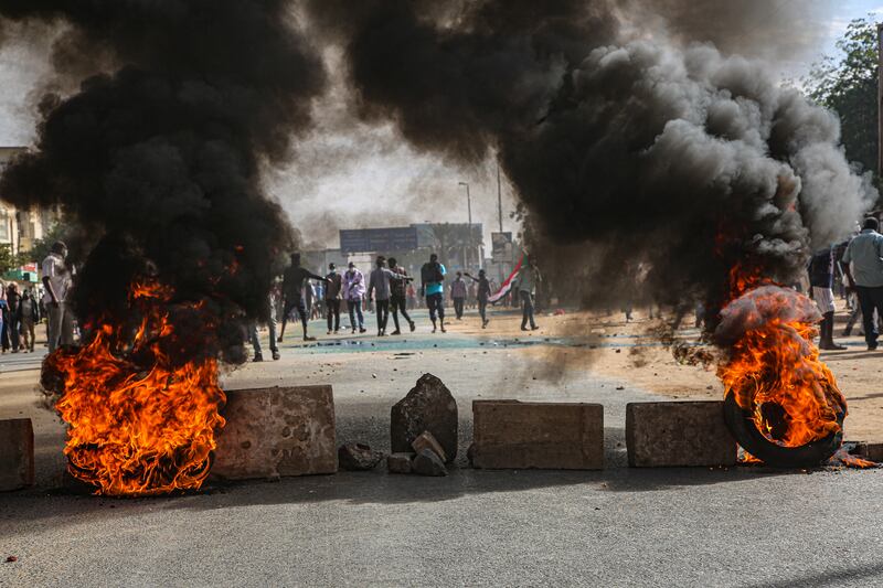 People burn tyres as they clash with security forces in Khartoum.  EPA