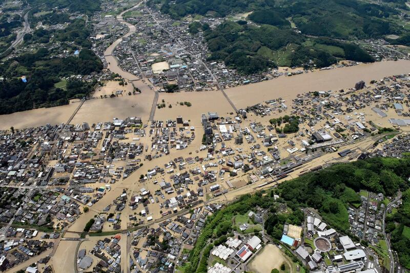 Areas are inundated in muddy waters that spilled over from the Kuma River in Hitoyoshi, Kumamoto prefecture. Kyodo News via AP