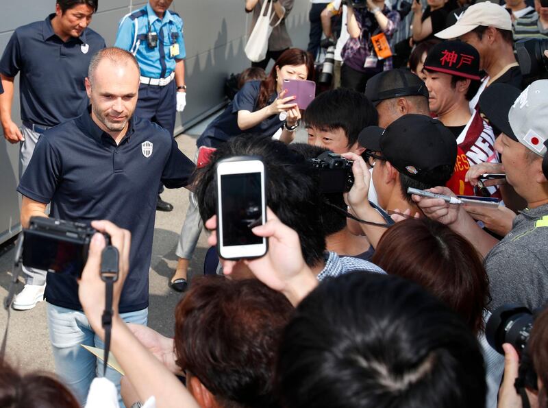 Iniesta is welcomed by fans upon arrival at Kansai International Airport. Kyodo News / AP