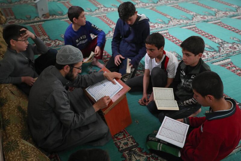 Syrian boys read the Quran at a mosque  in Syria's northwestern city of Idlib amid the COVID-19 pandemic.  AFP