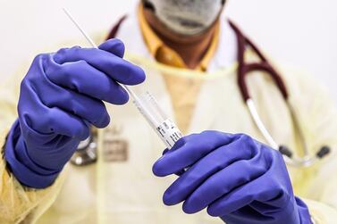 A doctor carries out a coronavirus test at a hospital in the UAE. Victor Besa / The National 