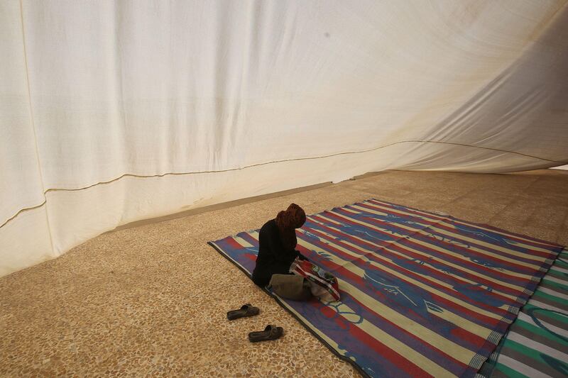 TOPSHOT - A displaced Iraqi woman, who fled the fight between Iraqi forces and the Islamic State group in Tal Afar, sits inside a tent at the Badush camp, 150 kilometres southeast of Tal Afar, on August 25, 2017. 
Iraqi authorities and aid groups set up the camp to host those displaced from the last major battle in the northern province of Nineveh, but rows of tents set up for the displaced remain empty, except for a few doctors and guards.
 / AFP PHOTO / AHMAD AL-RUBAYE