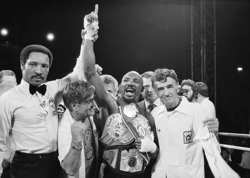 In this April 1985 file photo, middleweight champion Marvin Hagler celebrates his title with his manager, Pat Petronelli, and co-manager, Goody Petronelli, in Las Vegas. Hagler knocked out Thomas "Hitman" Hearns in the third round of the boxing bout. Hagler, the middleweight boxing great whose title reign and career ended with a split-decision loss to “Sugar” Ray Leonard in 1987, died Saturday, March 13, 2021. He was 66. AP