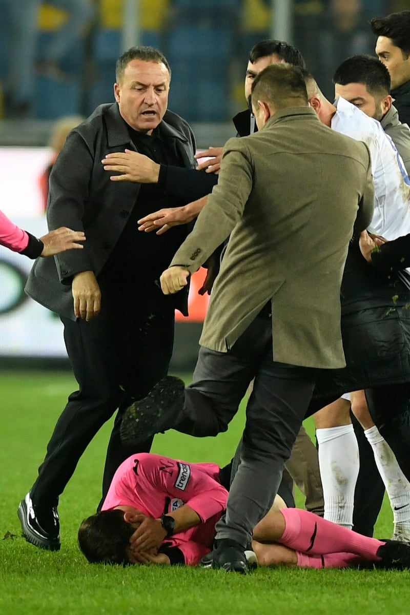 An unidentified man kicks referee Halil Umut Meler. AP