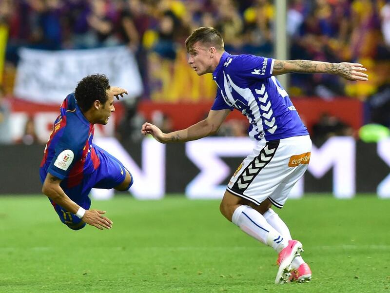 Barcelona’s Brazilian forward Neymar, left, (L) falls in front of Alaves defender Carlos Vigaray. Ander Gillenea / AFP