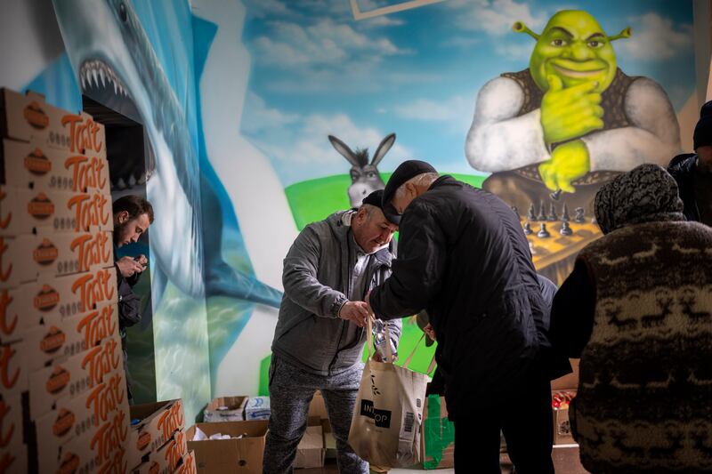 Ukrainians receive humanitarian aid organised by local volunteers in Irpin. AP