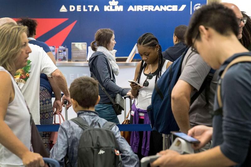 Travellers wait in line at the Delta check-in counter at LaGuardia Airport. AFP