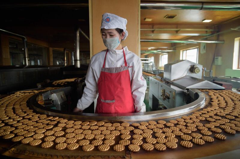 A worker monitors the production line for Taeha brand cakes at the Unha Taesong Foodstuff factory in Pyongyang, North Korea. AFP