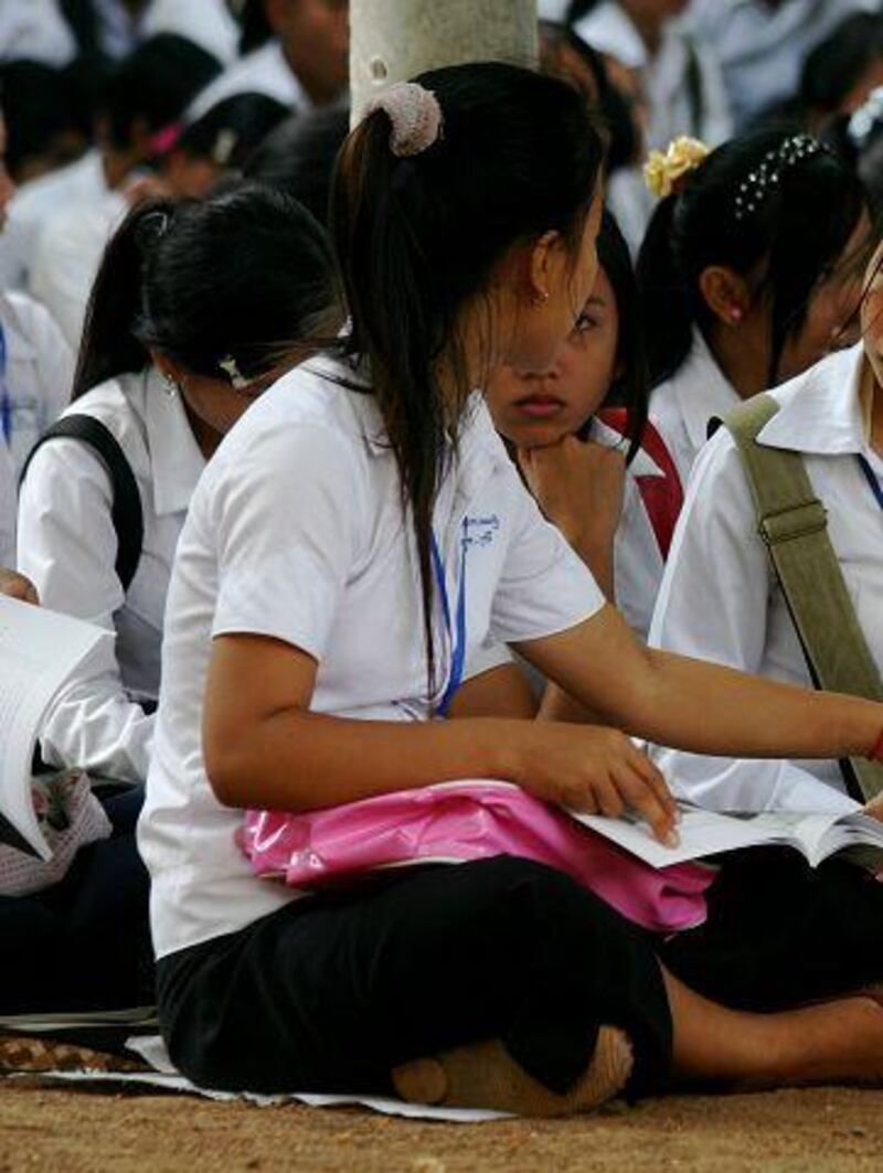 Students look through Cambodia's first textbook of Khmer Rouge history, which was issued to them earlier this week.