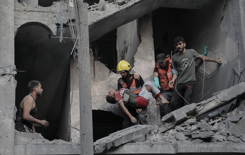 A child is recovered from the rubble of a residential building levelled in an Israeli air strike, in Khan Younis. EPA