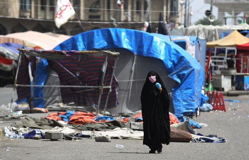 An Iraqi woman wearing a mask walks in an empty street in Baghdad.  AFP