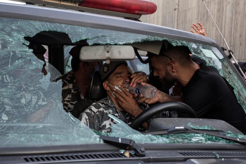 BEIRUT, LEBANON - SEPTEMBER 12: An anti-government protester gives water to a policeman after other protesters attacked his vehicle during a march toward the Presidential Palace, on September 12, 2020 in Baabda, Beirut, Lebanon. (Photo by Sam Tarling/Getty Images)