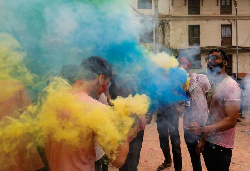 People use coloured smoke as they gather to celebrate Holi, the festival of colours in Kathmandu, Nepal. Reuters