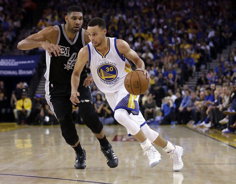 Golden State Warriors' Stephen Curry, right, dribbles past San Antonio Spurs' Tim Duncan during the first half of an NBA basketball game on Thursday, April 7, 2016, in Oakland, Calif. (AP Photo/Marcio Jose Sanchez)