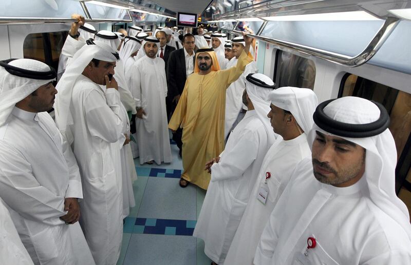 Dubai ruler Sheikh Mohammed bin Rashid al-Maktoum (yellow) takes a ride through the second metro rail network during its inauguration, after a two-year delay, in the Gulf emirate of Dubai on September 9, 2011. AFP PHOTO/KARIM SAHIB (Photo by KARIM SAHIB / AFP)