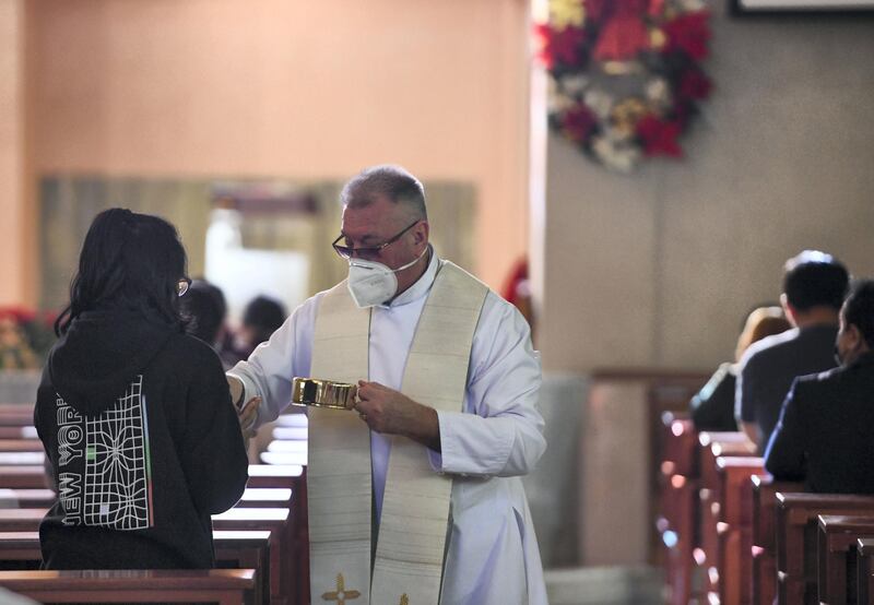 Abu Dhabi, United Arab Emirates - Father Stepan Lylak, from Ukraine hands out  the sacramental bread for communion during Christmas mass, at St. JosephÕs Cathedral, Mushrif. Khushnum Bhandari for The National