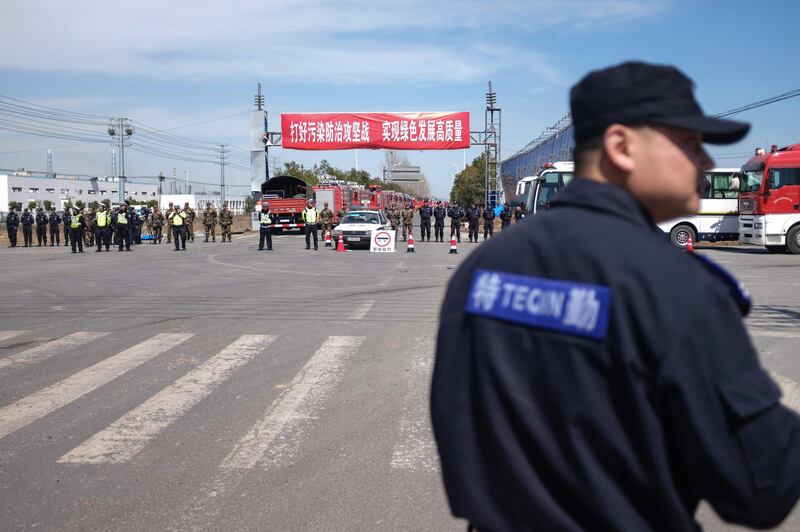 Security guards patrol as police officers block off the road leading to the site of an explosion in Yancheng in China's eastern Jiangsu province. AFP